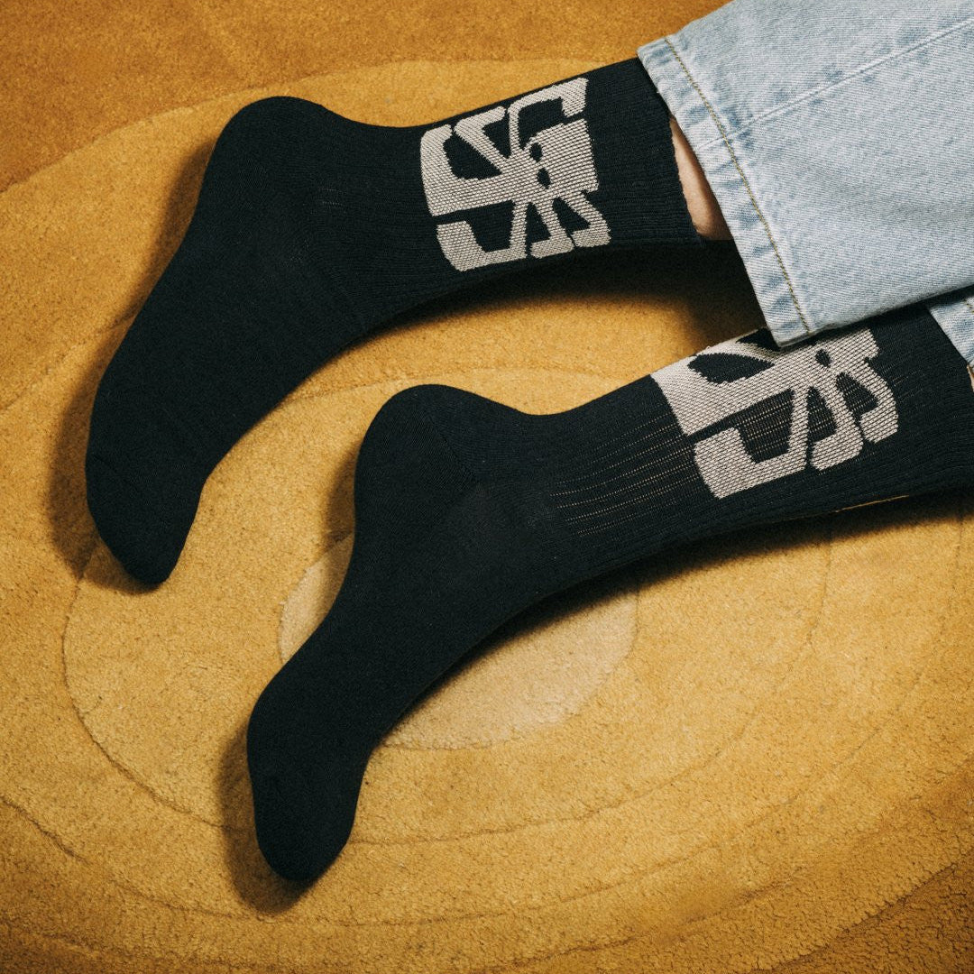 chaussettes jonsen island artist navy avec poulpe blanc portées sur un tapis orangé retro