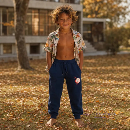 Pantalon Joggy Kid Jonsen Island en situation, coupe souple resserrée aux chevilles et motif pieuvre placé sur la jambe