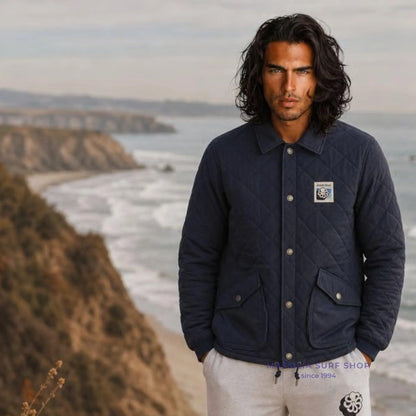 Veste surfwear Jonsen Island Big Sur bleu marine en situation sur la côte, matelassage losangé et écusson poitrine