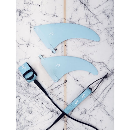 just leash surf 8' bleu vu posé avec dérives de surf bleues assorties