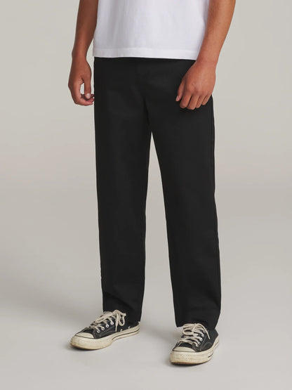 Vue de face du chino Katin Clark noir porté avec un t-shirt blanc, jambes droites et longueur descendant sur les baskets.