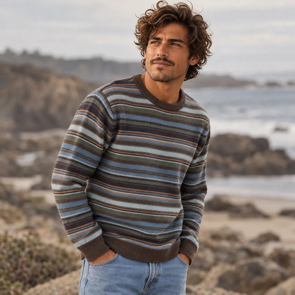 Pull Katin Hitch Sweater Tempest Blue porté en bord de mer, rayures horizontales multicolores, col rond et manches longues.