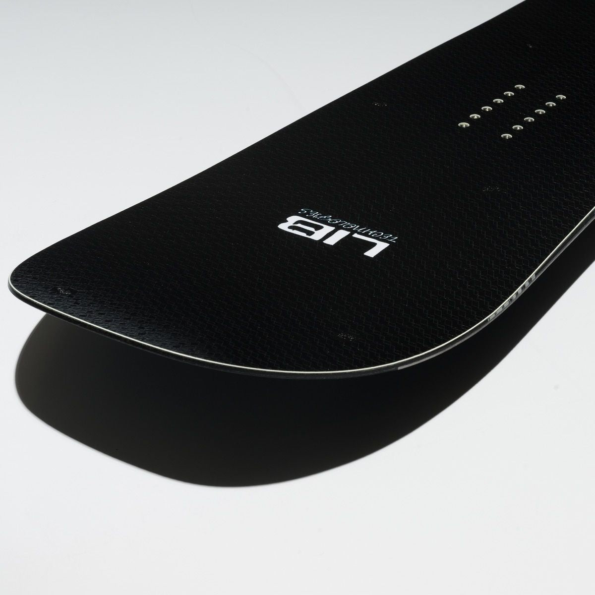Gros plan sur le nose arrondi du snowboard DPR, topsheet noir texturé, logo Lib Tech blanc et inserts de fixation visibles.