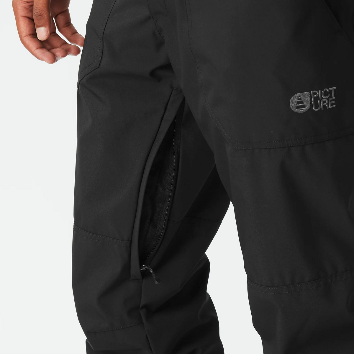 Gros plan sur la cuisse du Picture Plan Pants Black avec logo et zip technique
