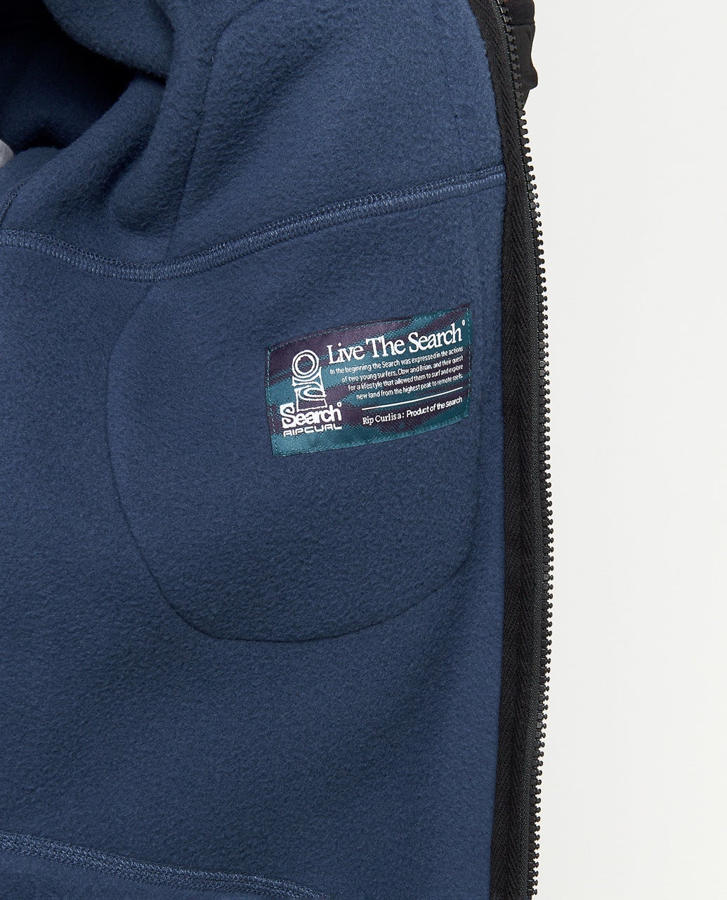 Détail de la partie basse en polaire bleu marine, avec poche latérale intégrée et petit patch rectangulaire