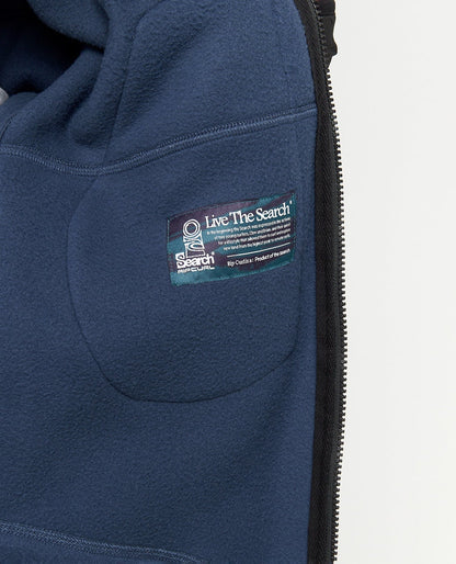 Détail de la partie basse en polaire bleu marine, avec poche latérale intégrée et petit patch rectangulaire