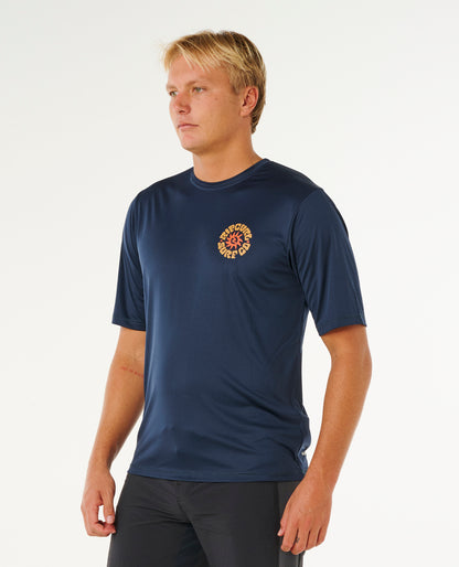 Tee-shirt lycra Rip Curl Pacific Rinse Navy porté de trois-quarts avec logo poitrine contrasté