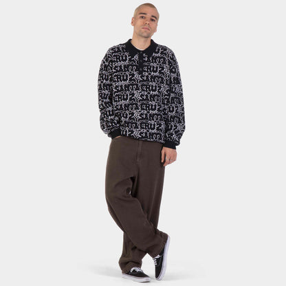Silhouette en pied avec pantalon brun à jambes larges, coupe décontractée adaptée à l’univers skateboard