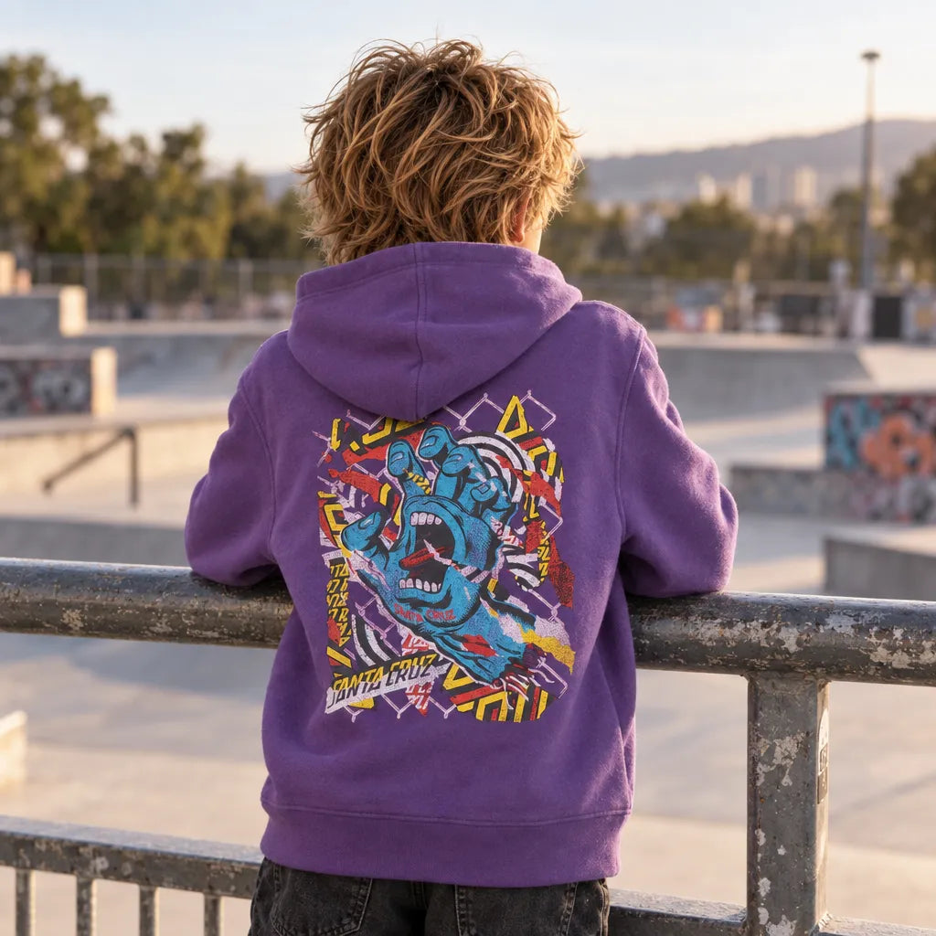 Hoodie enfant Santa Cruz Damaged Hand violet vu de dos au skatepark, large illustration multicolore avec main bleue hurlante