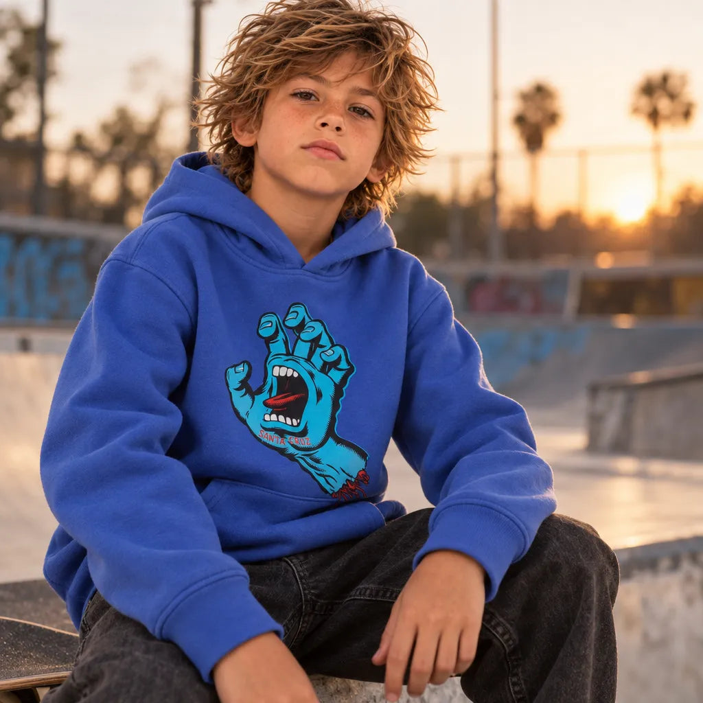 Enfant assis portant le sweatshirt Santa Cruz hoodie Screaming Hand bleu de face au skatepark