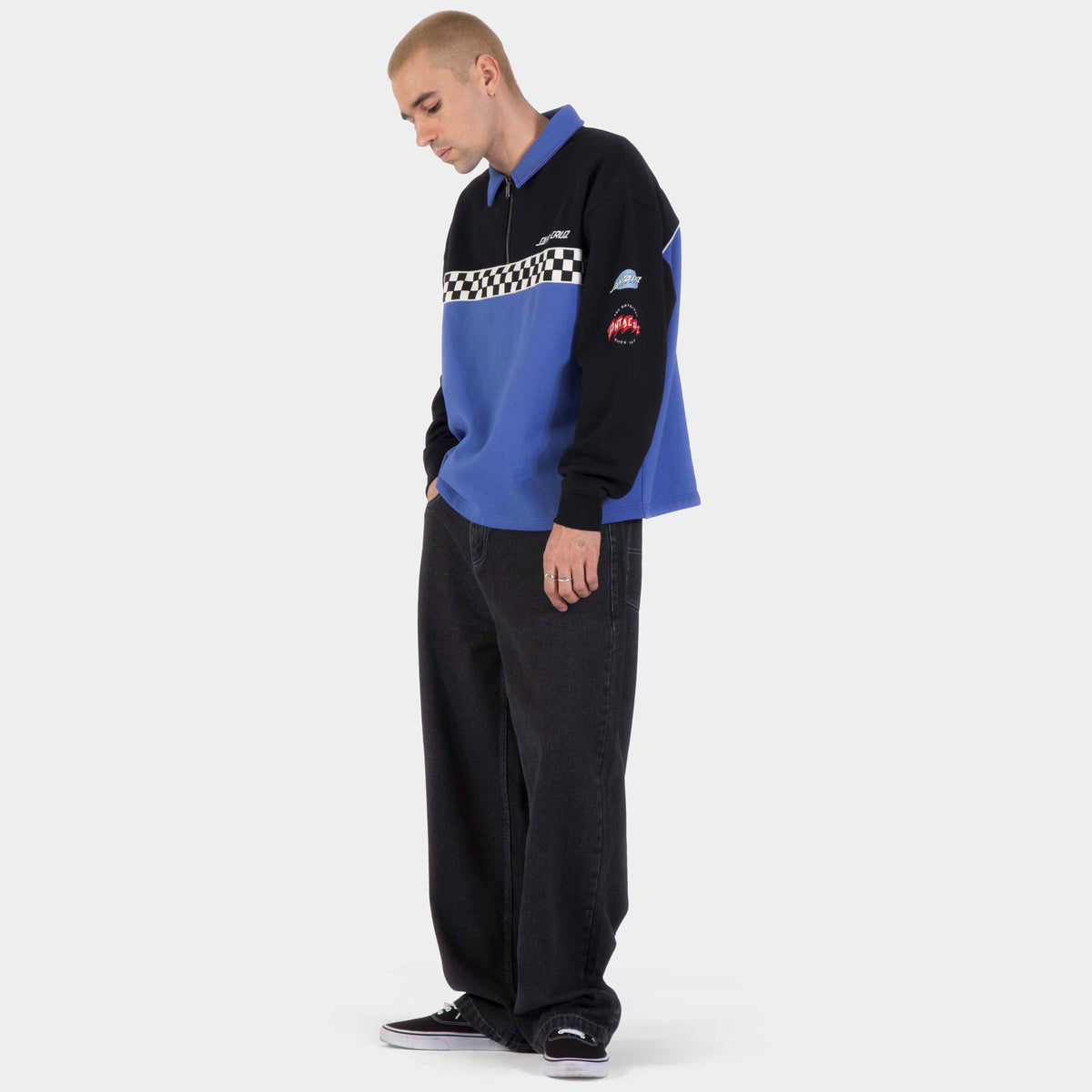 Sweat Santa Cruz porté de profil, montrant les manches noires, le panneau bleu et le petit marquage graphique sur la manche