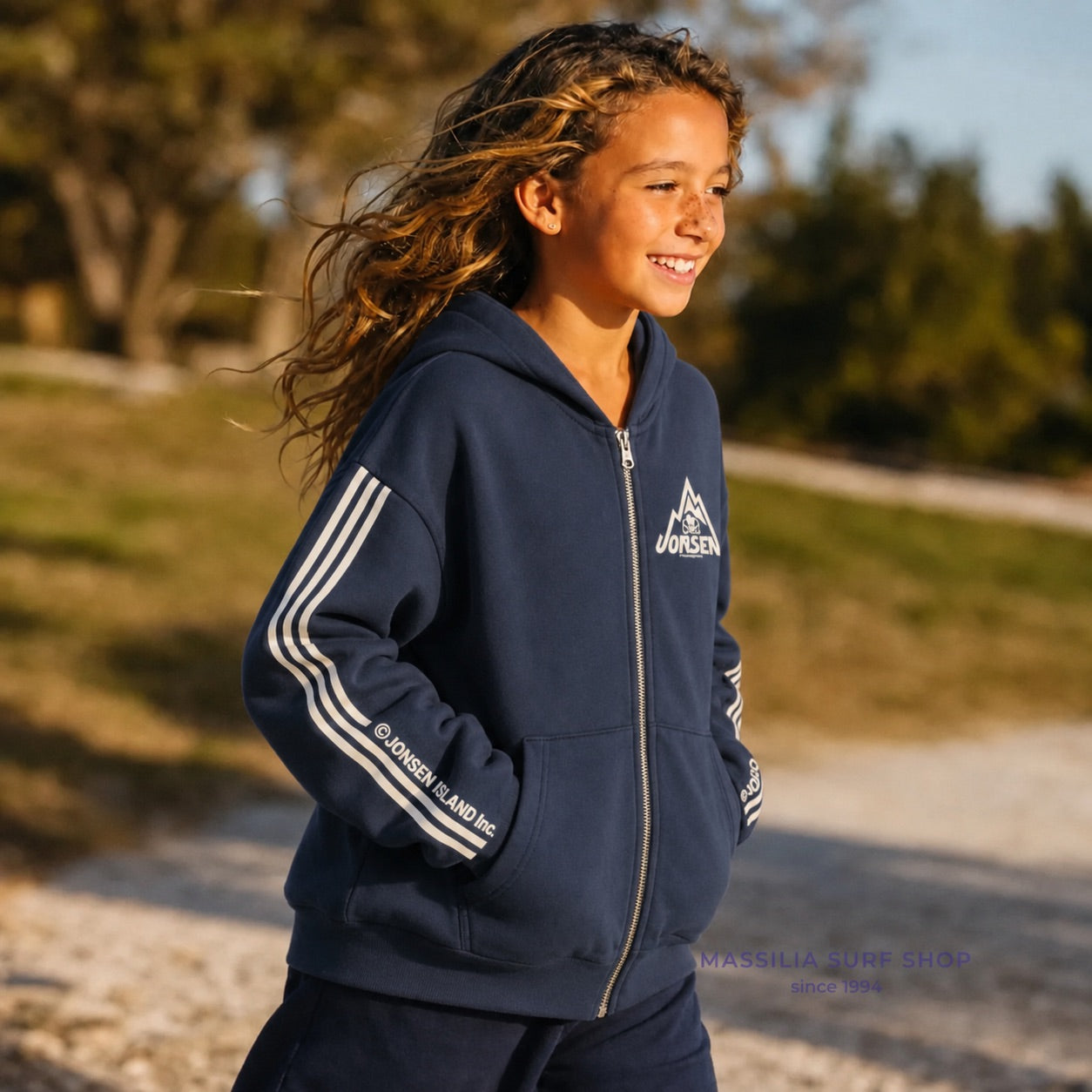 Sweat zippé surfwear Big Rock Stripes enfant bleu marine porté, trois bandes blanches sur les manches et petit emblème montagne poitrine
