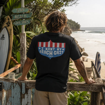Tee-shirt homme Vissla noir I Want My Beach Grit porté de dos face à la plage, visuel surf vintage, ambiance surfwear premium